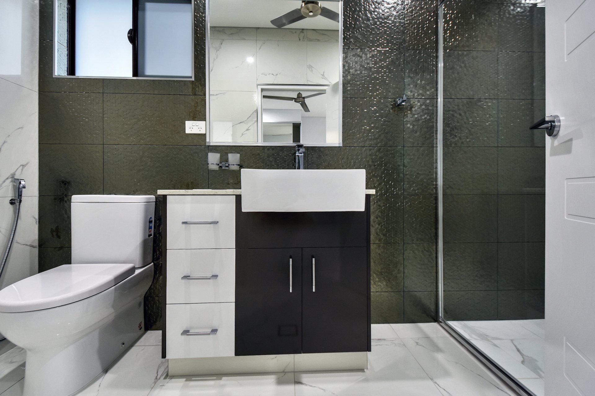 A bathroom with a toilet a sink and a mirror