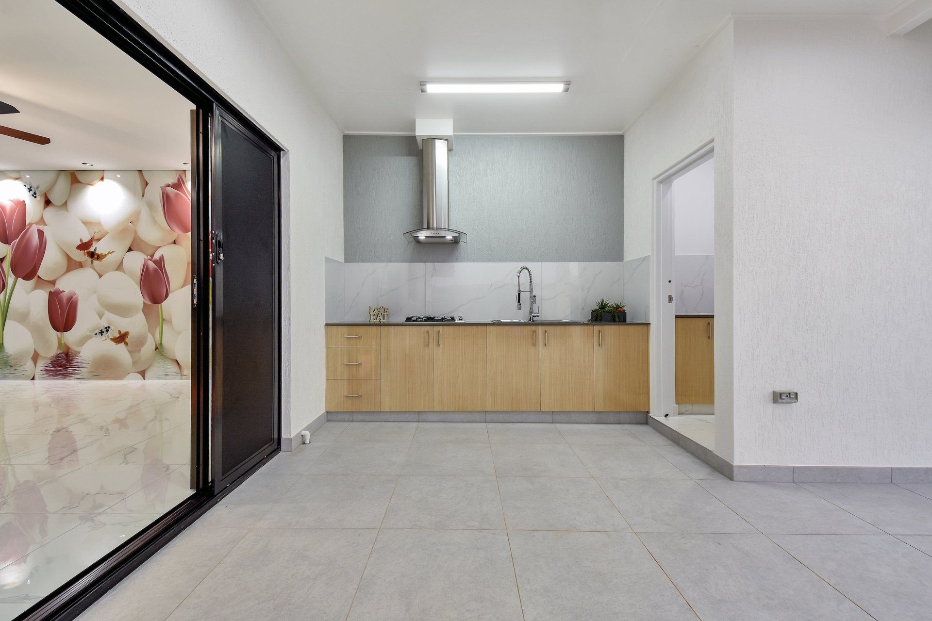 An empty kitchen with a picture of flowers on the wall