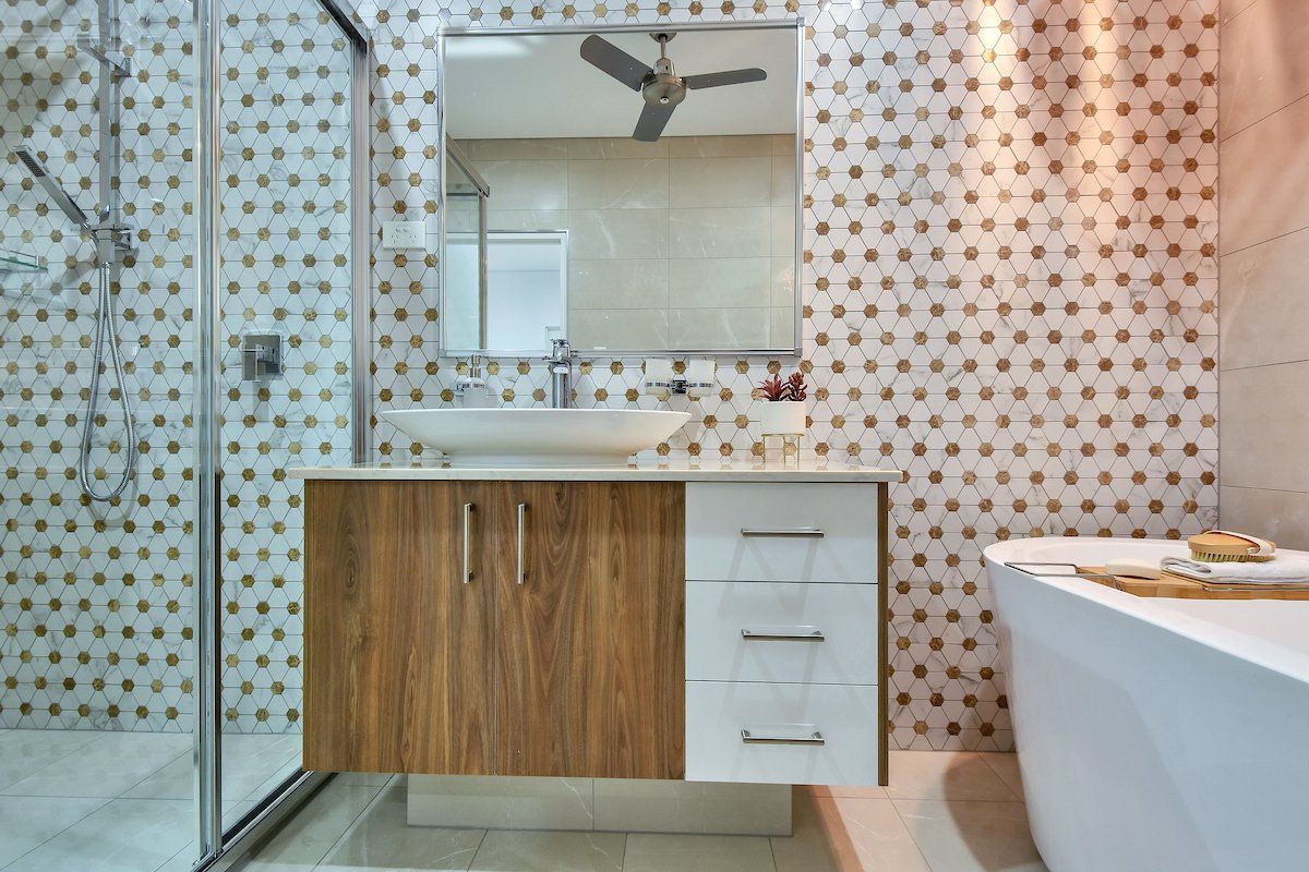 A bathroom with a sink , tub , mirror and shower.
