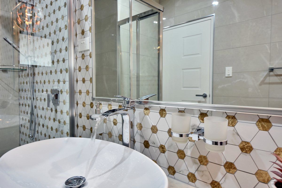 A bathroom with a sink , mirror and shower.