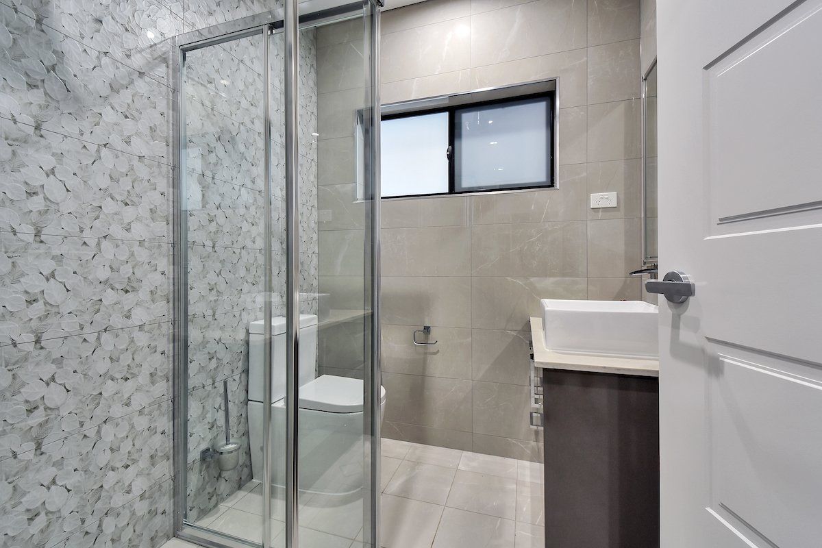 A bathroom with a toilet , sink and shower stall.