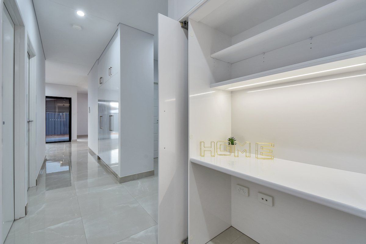 A hallway with a desk in the middle of it.