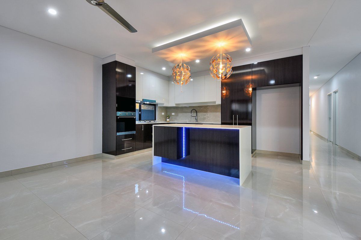 A kitchen with a blue island and a ceiling fan.