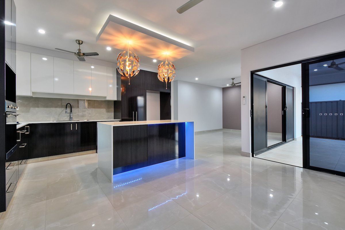 A kitchen with black and white cabinets and a blue island