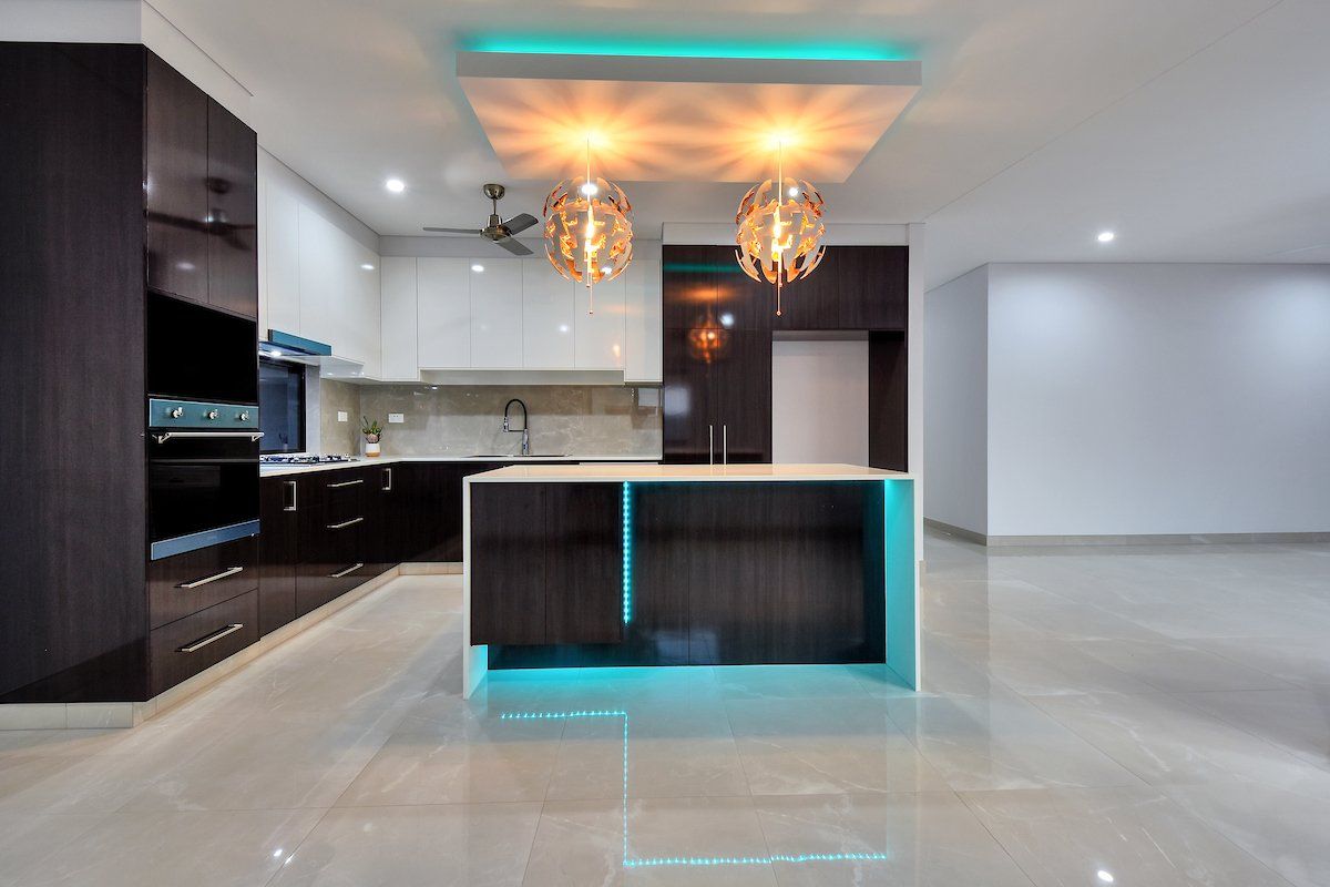 An empty kitchen with a blue island in the middle