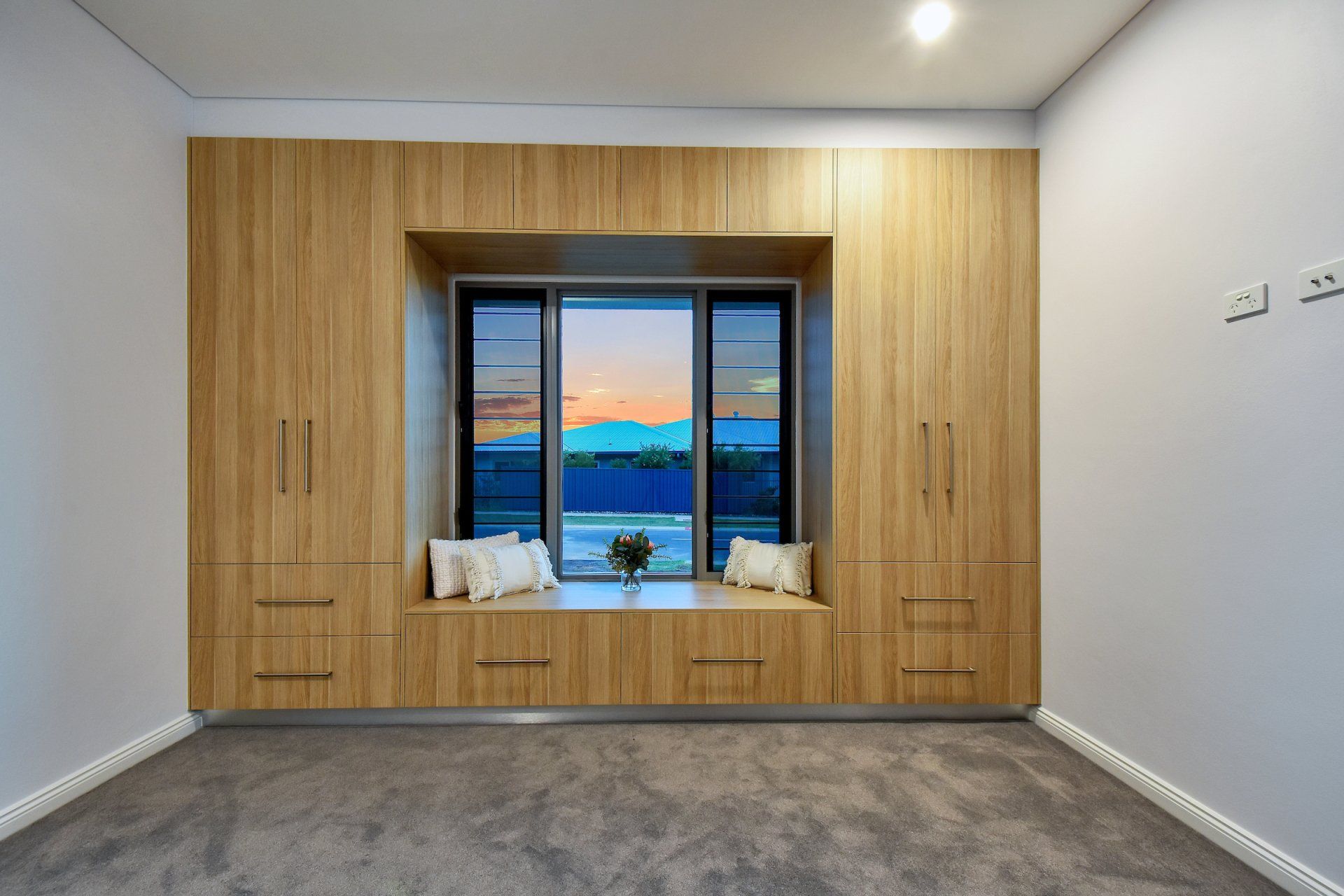 A room with a large window and wooden cabinets