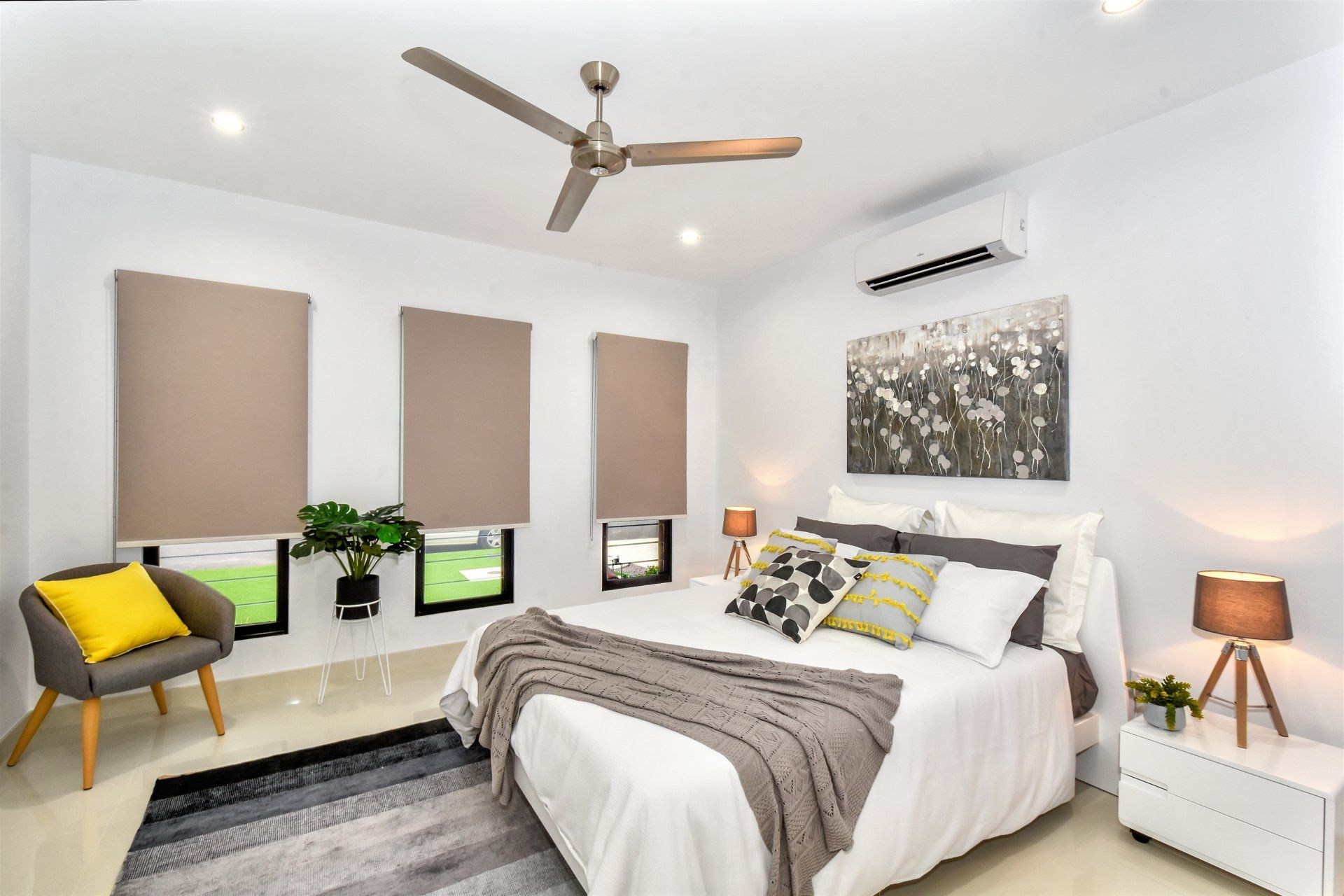 A bedroom with a bed , chair , nightstand and ceiling fan.