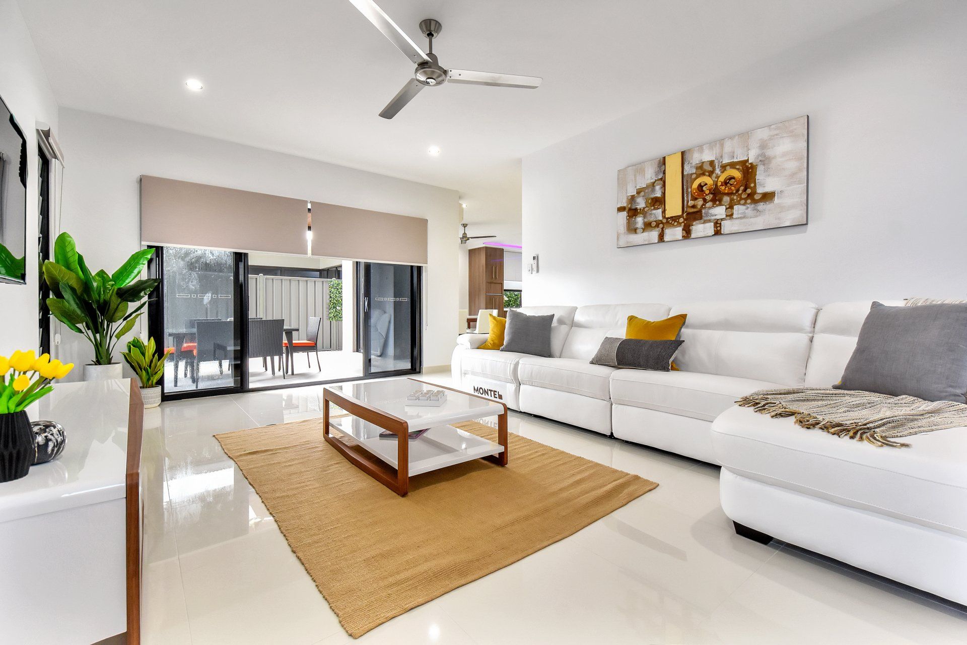 A living room with a couch , coffee table , and ceiling fan.