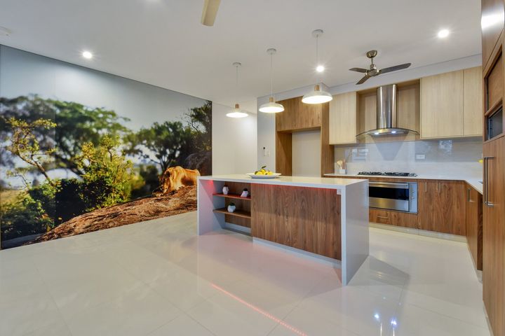 A kitchen with a large island and a painting on the wall.