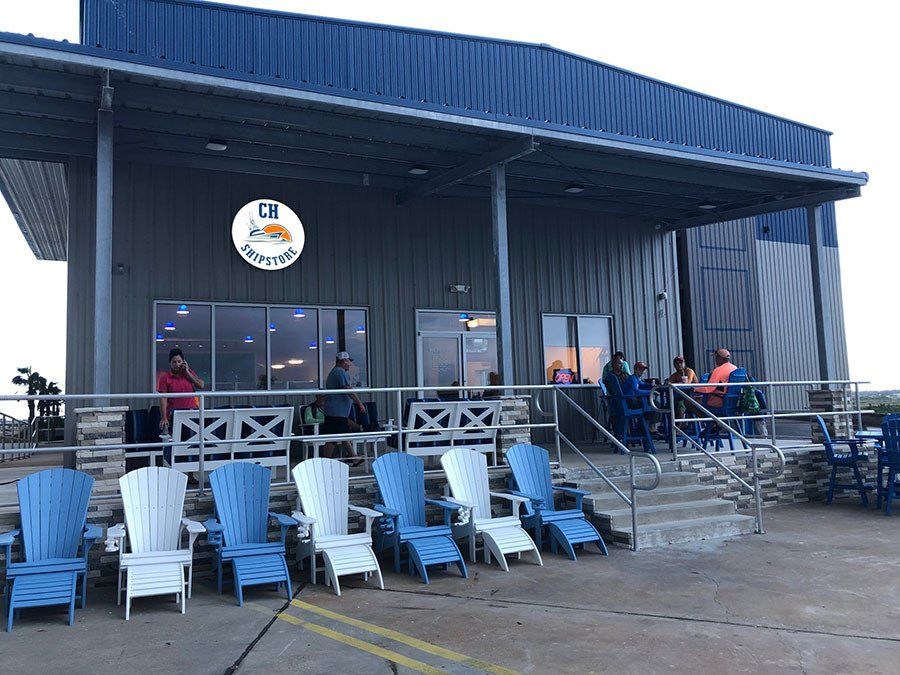 A row of blue and white chairs are lined up in front of a building.