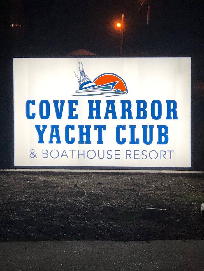 A sign for the cove harbor yacht club and boathouse resort