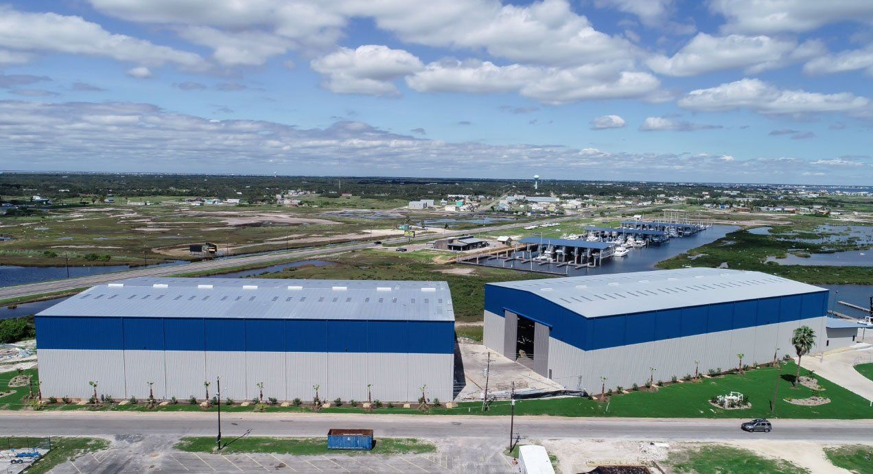 An aerial view of two buildings next to a body of water.