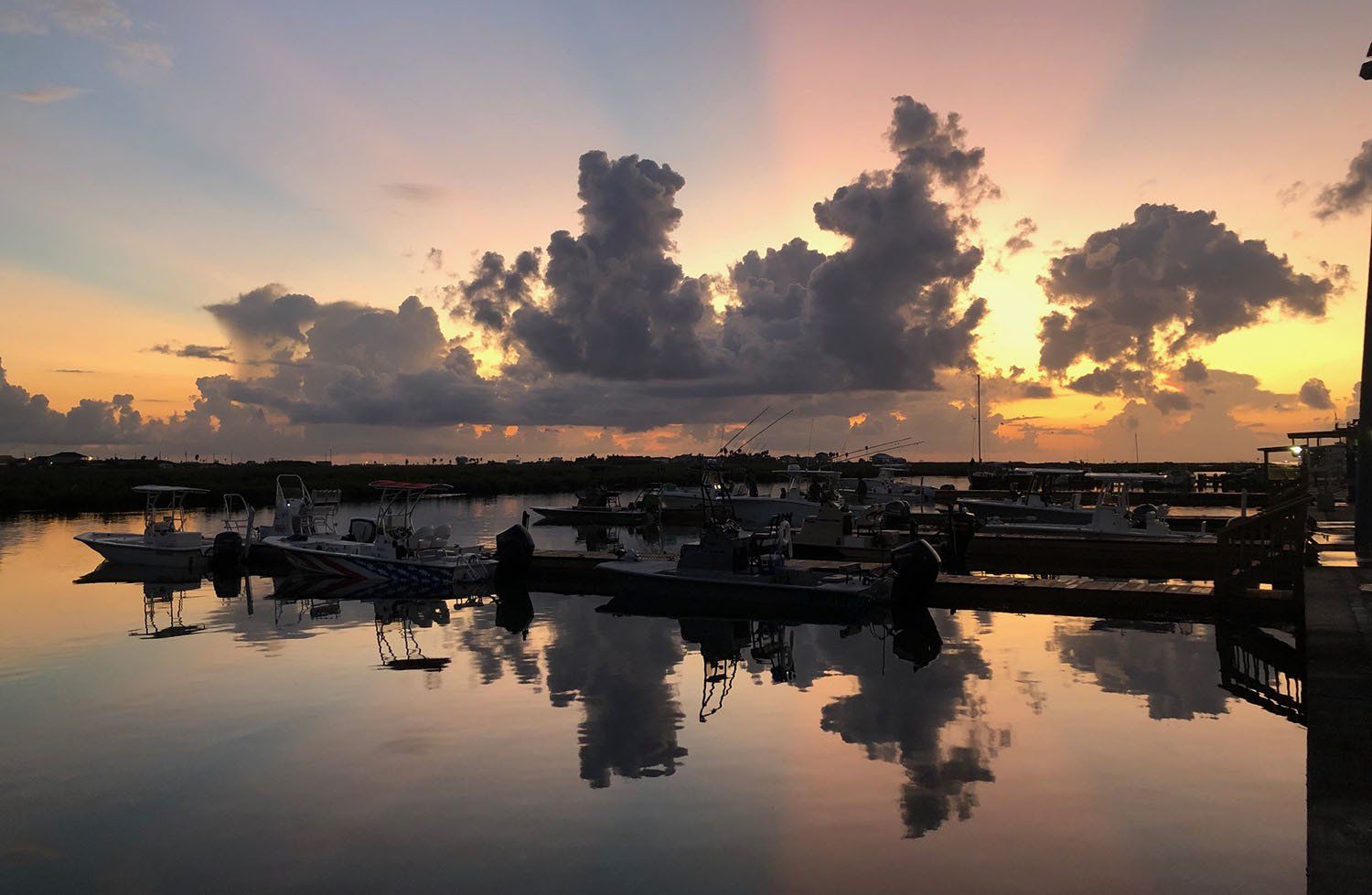 A sunset over a marina with boats docked in the water