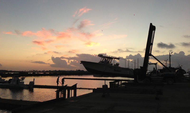 A boat is docked in a harbor at sunset