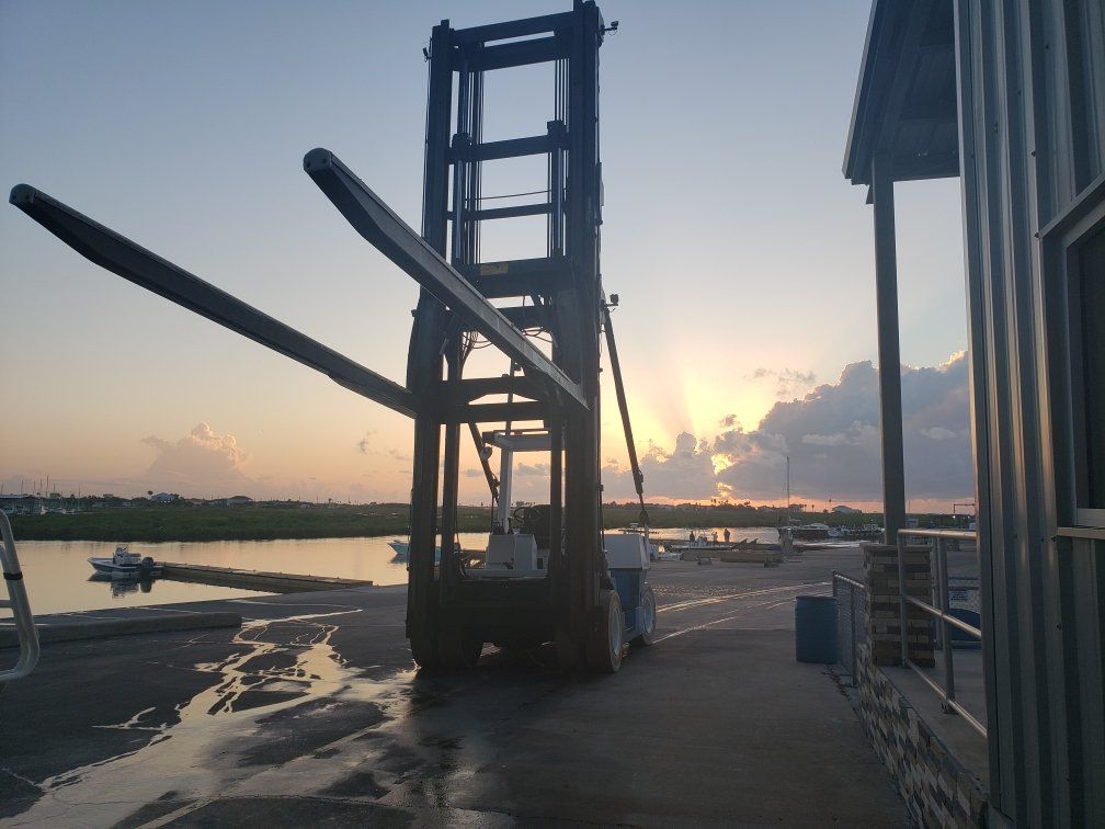 A forklift is being loaded with a large piece of metal