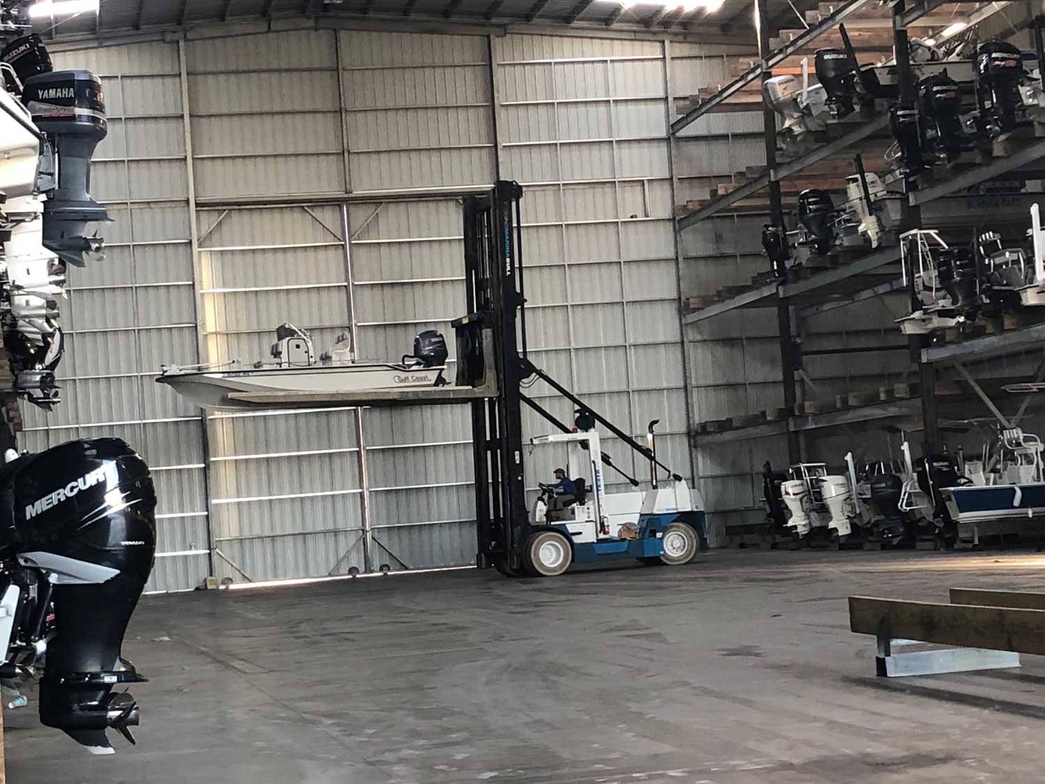 A large warehouse filled with lots of boats and engines.