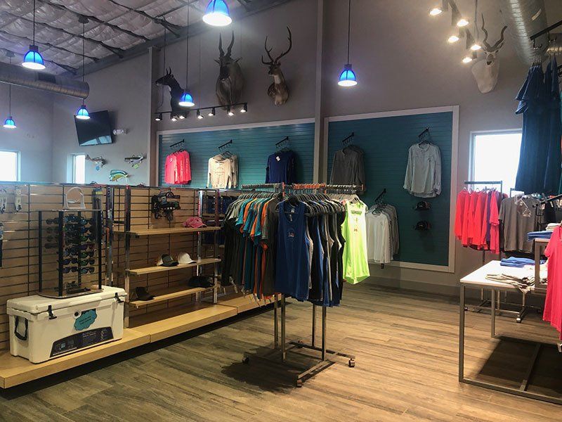 A store filled with lots of clothes and a cooler.