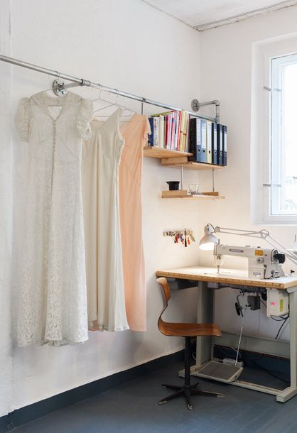 Brautkleider an einer Stange haengend und eine Naehmaschine