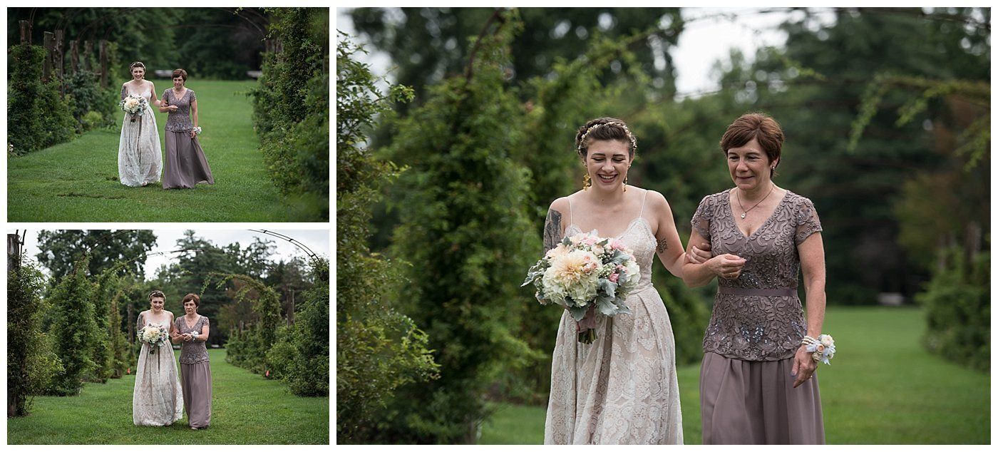 Two women in floral dresses walking arm in arm in a garden, carrying bouquets