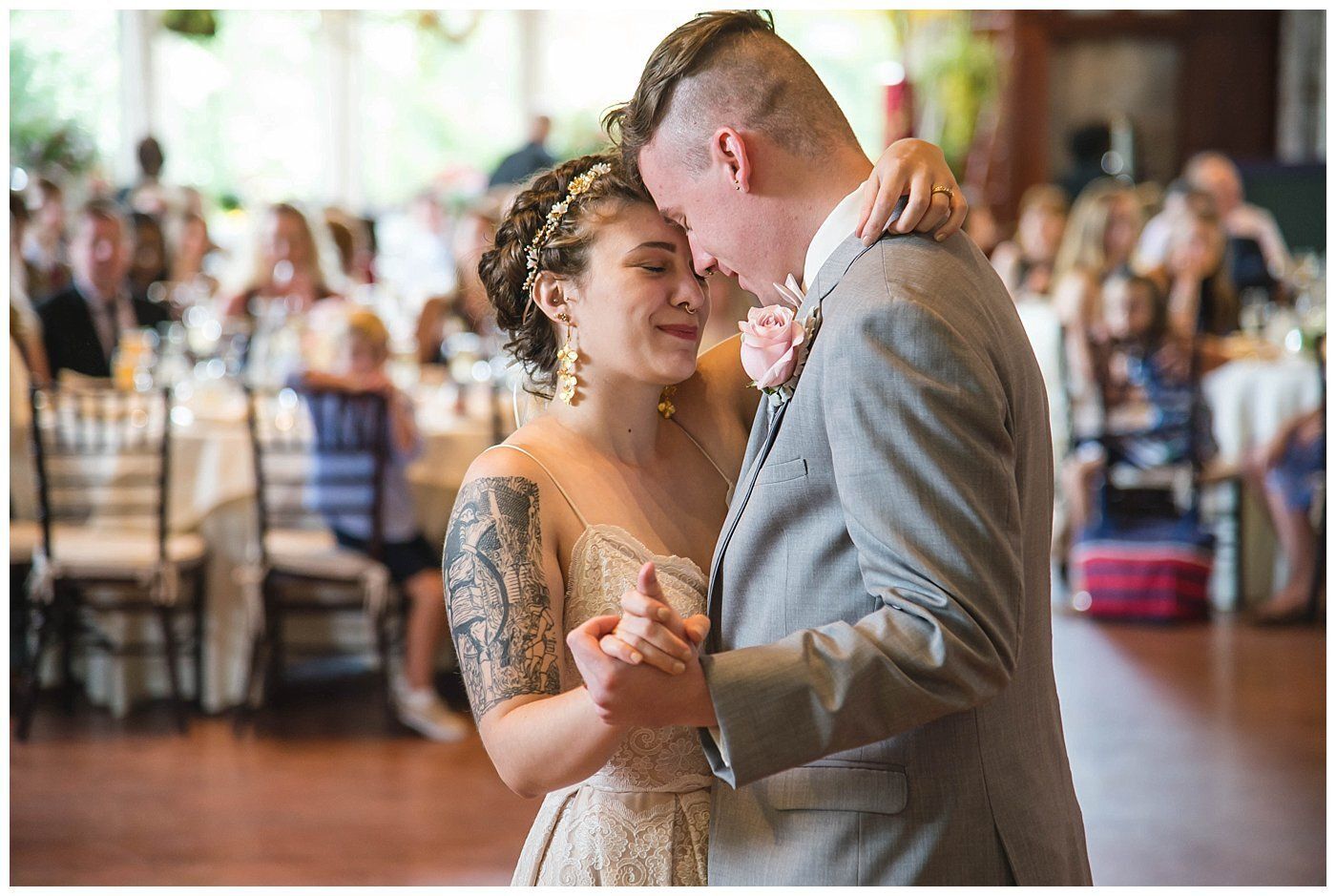 Couple slow dancing at a wedding reception, smiling and holding each other closely.