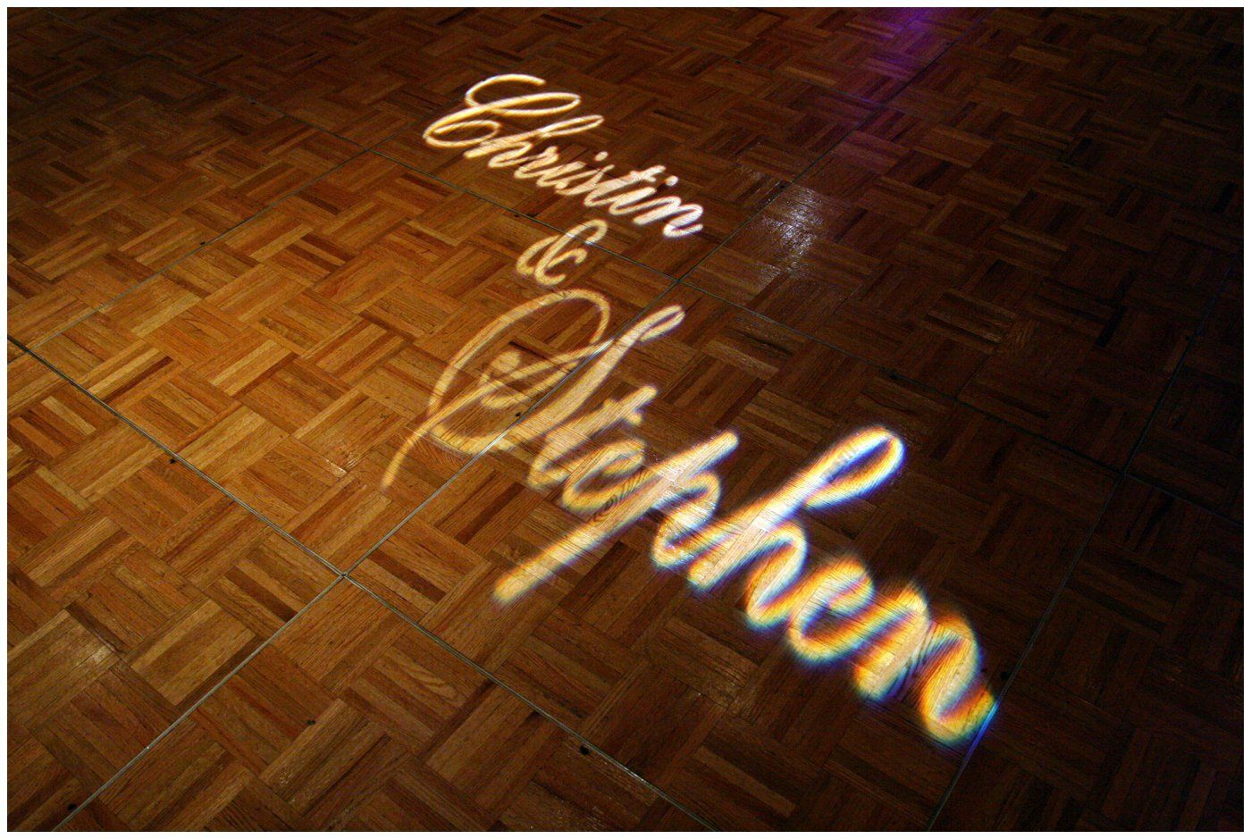 “Charlwin & Stephen” projected in white script on a wooden parquet floor