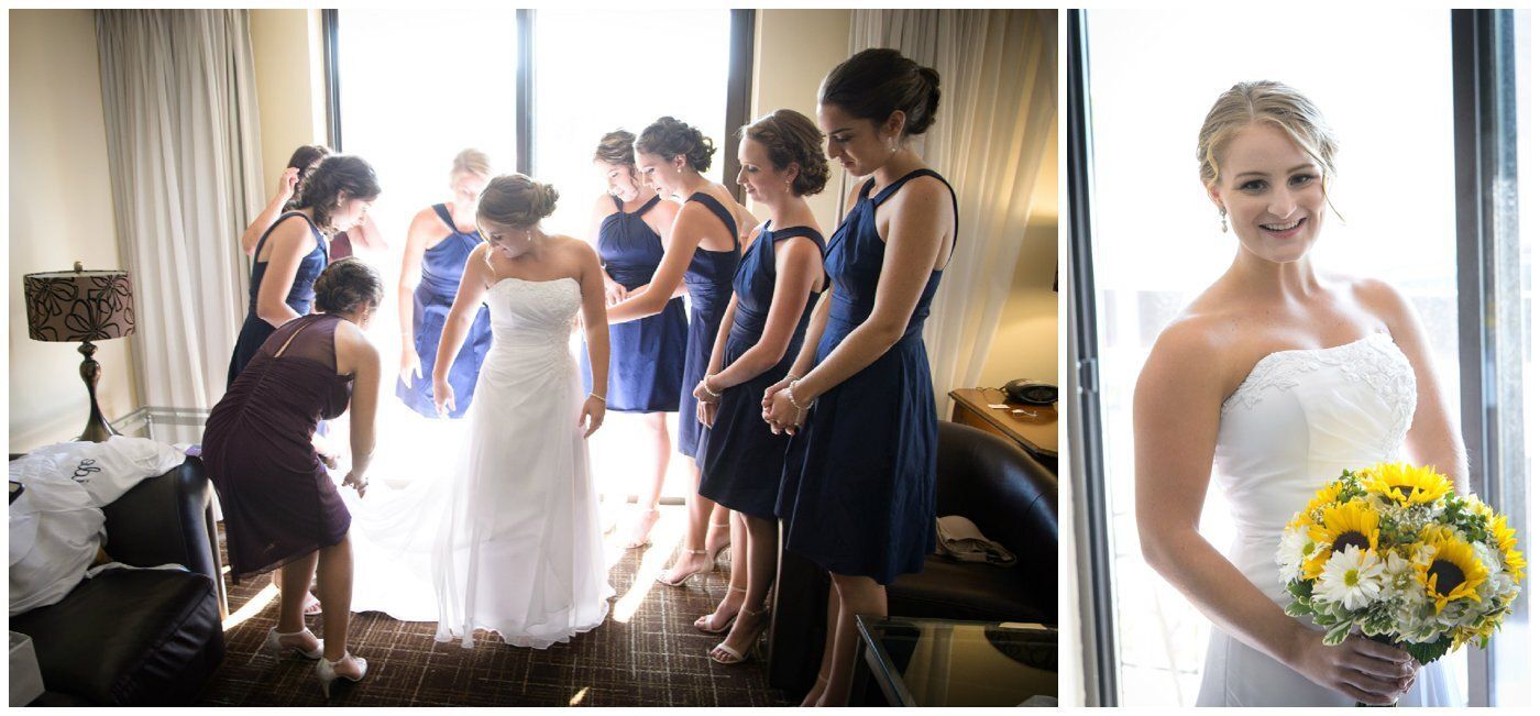 Bridesmaids help a bride in a white gown; another bride smiles holding yellow flowers.