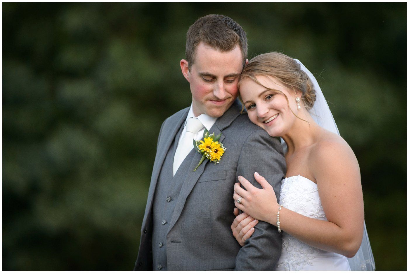 Bride and groom embracing outdoors, smiling in wedding attire