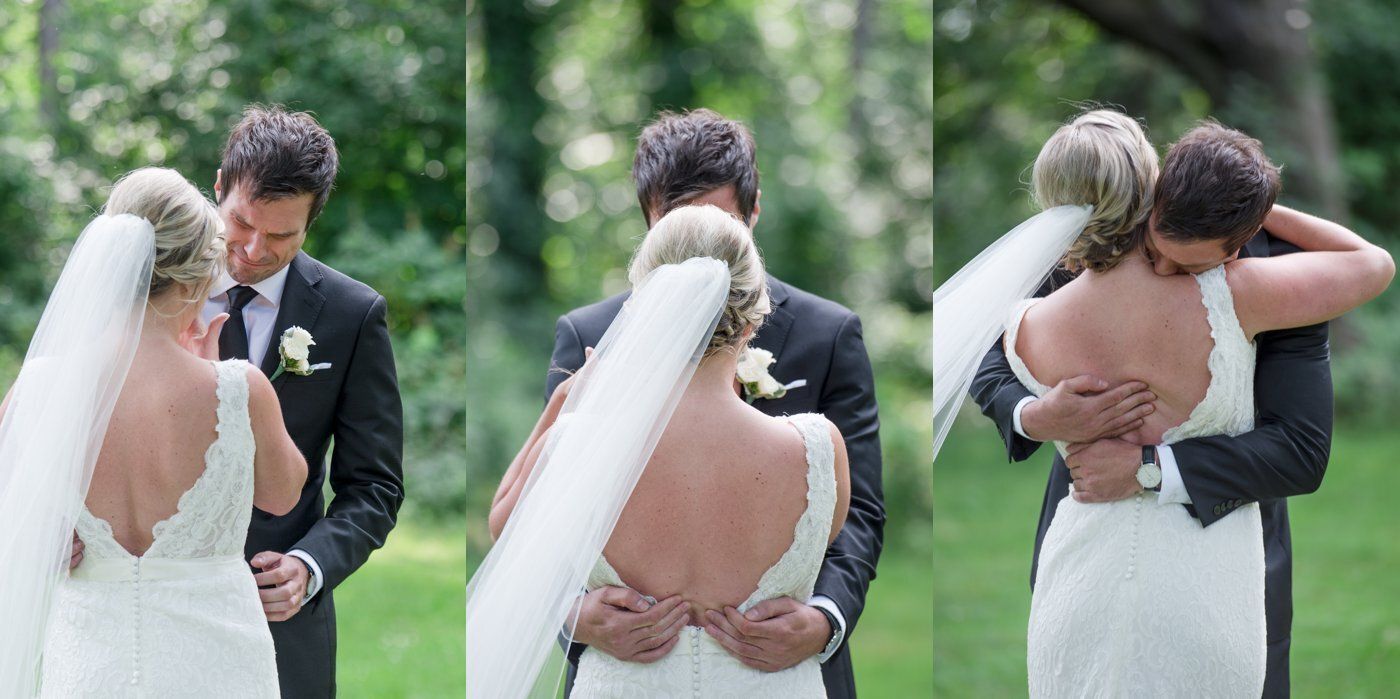 Bride and groom sharing a kiss during an outdoor wedding ceremony with the bride's veil flowing behind her