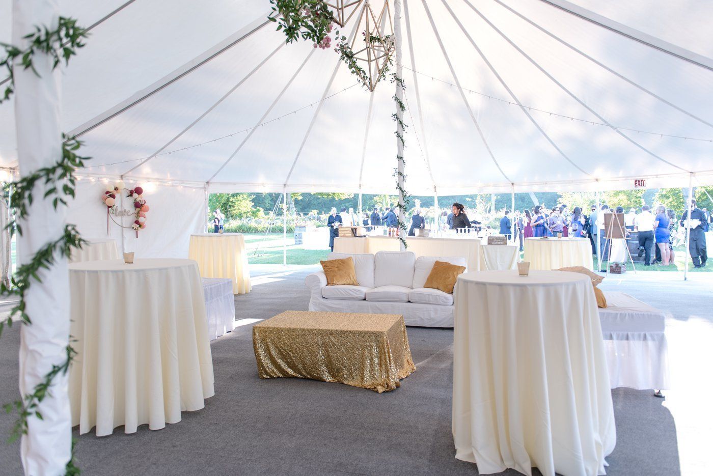 White event tent with sofas and cocktail tables set up for an outdoor gathering