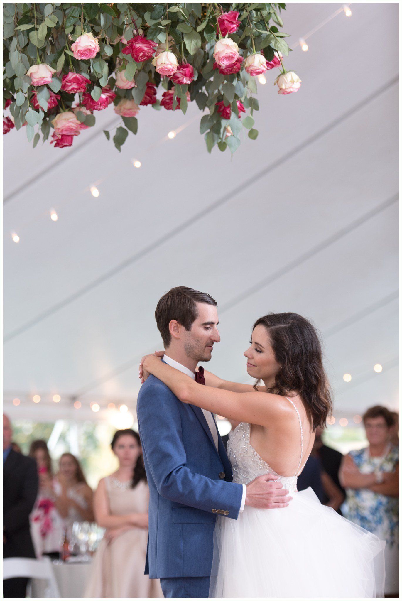 Bride and groom dancing under a flower-covered arch at a wedding reception