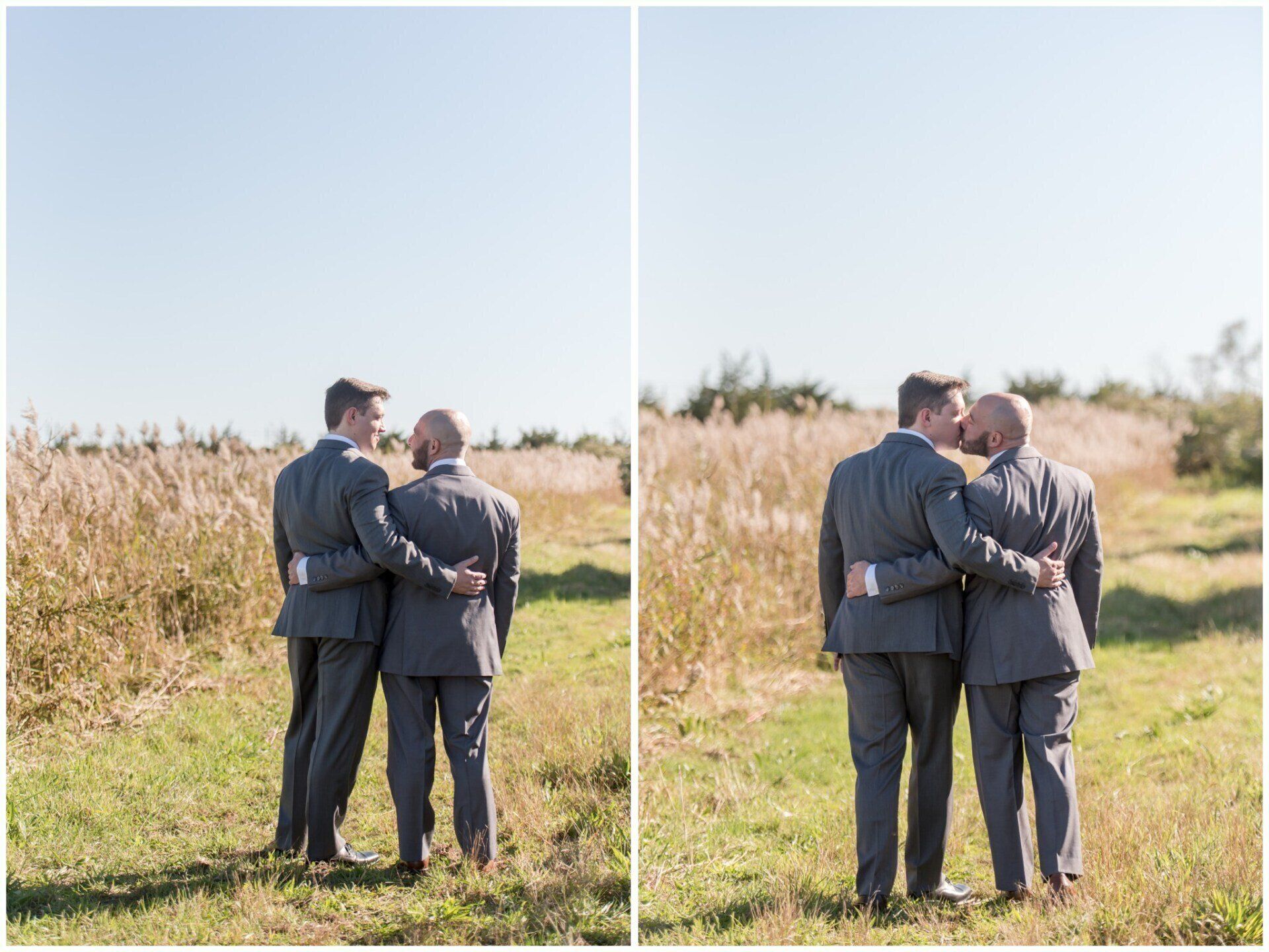 Two people in gray suits embracing in a sunny grassy field, shown side by side from behind.