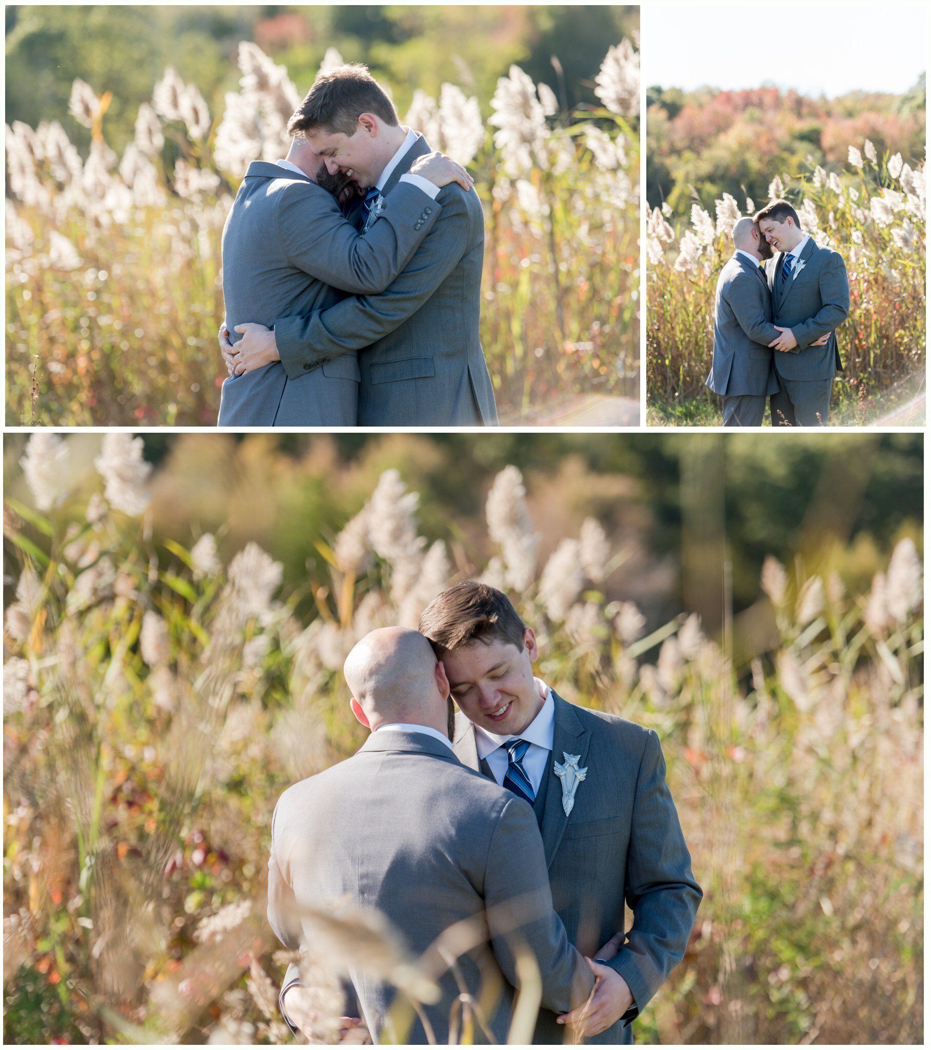 Two men in suits embrace and smile outdoors in a sunlit field of tall grass.