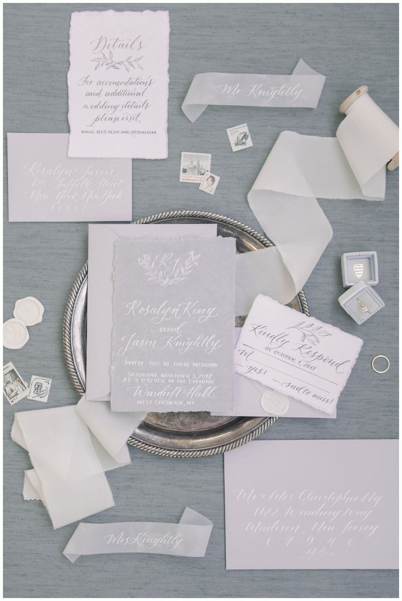 Assorted paper notes and envelopes arranged on a gray tabletop, with a decorative woven tray in the center