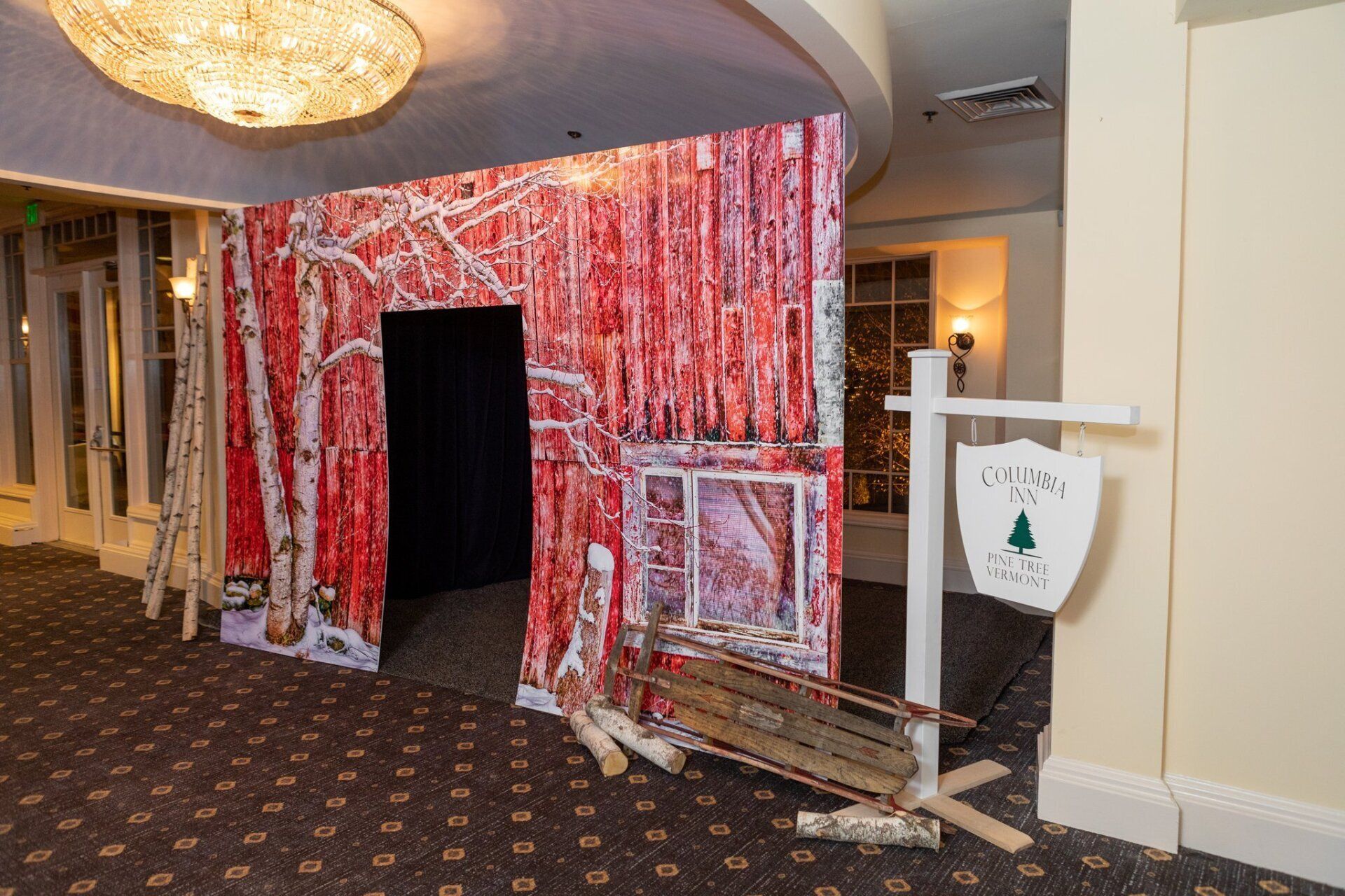 Red-and-white themed booth display with a dark doorway and white sign in a hallway.