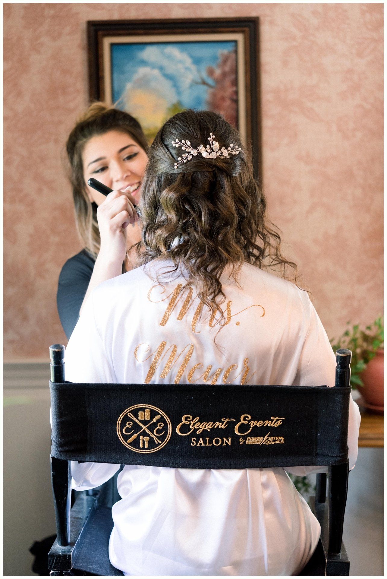 Makeup artist applying makeup to a seated client in a salon chair