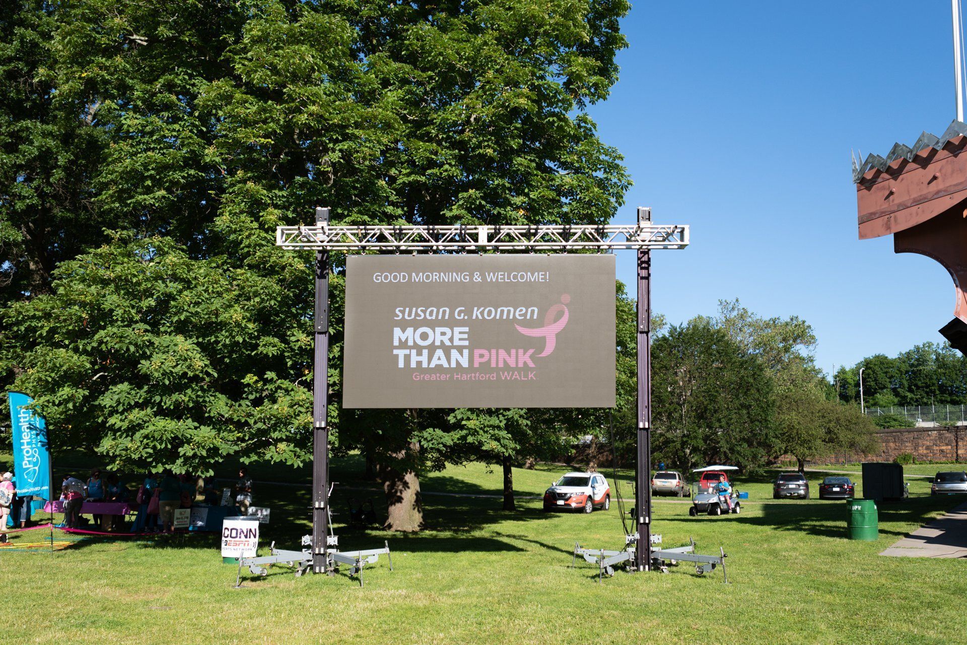 Outdoors, a banner on a metal frame reads “What I care for? More than pink.”