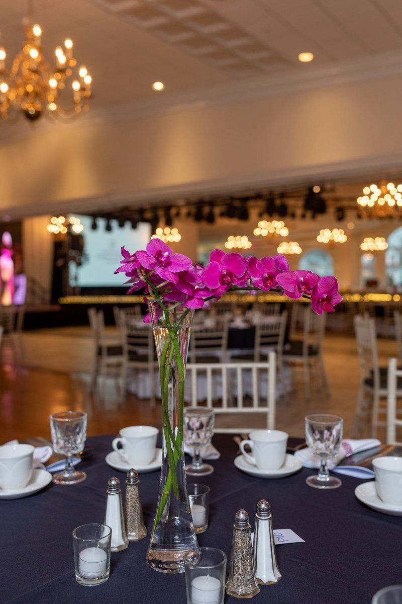 Flower centerpiece on a banquet table in a softly lit event hall