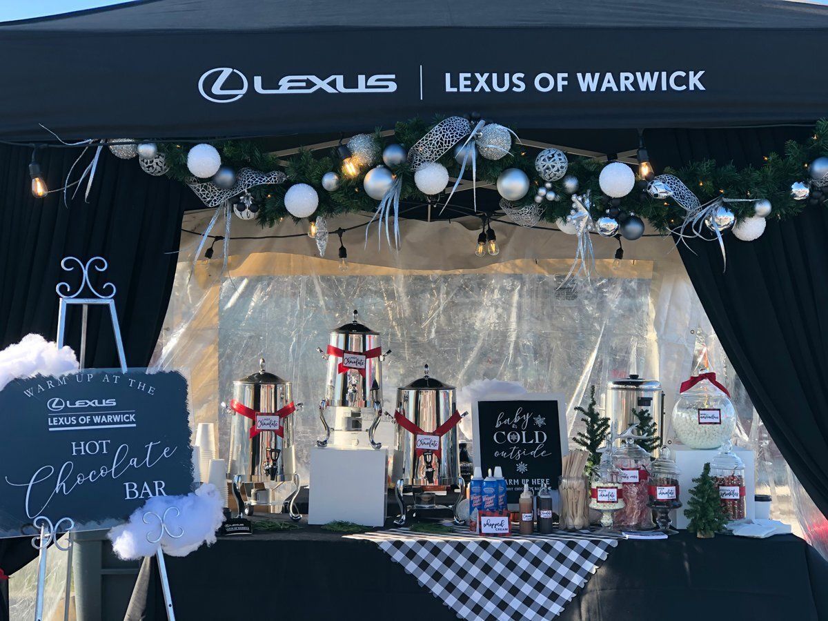 Festive Lexus of Warwick holiday display with lights, garlands, lanterns, and checkered tablecloths