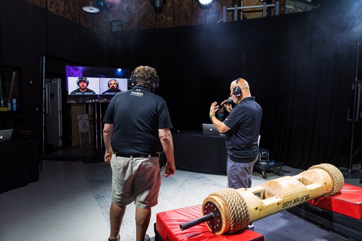 Two people filming in a studio beside a decorated cylindrical prop on a table