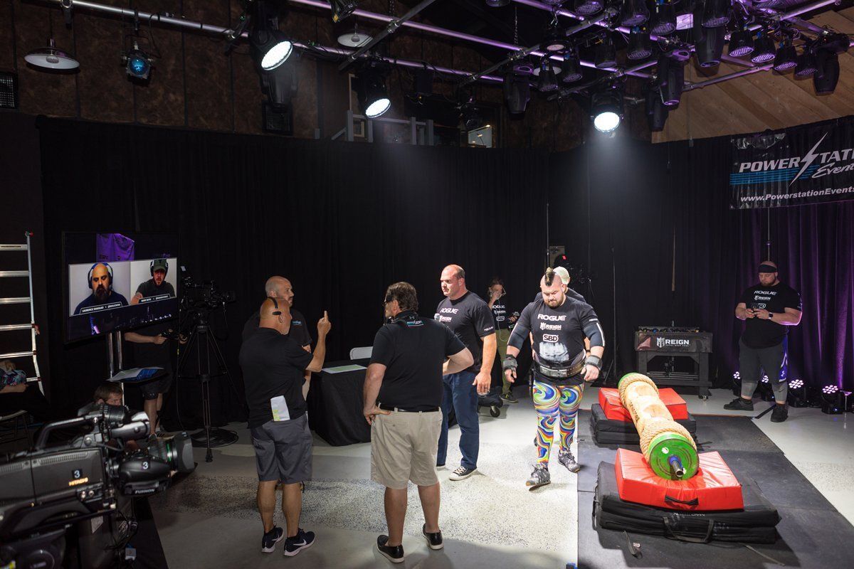 People standing around a small red go-kart on a stage under studio lights