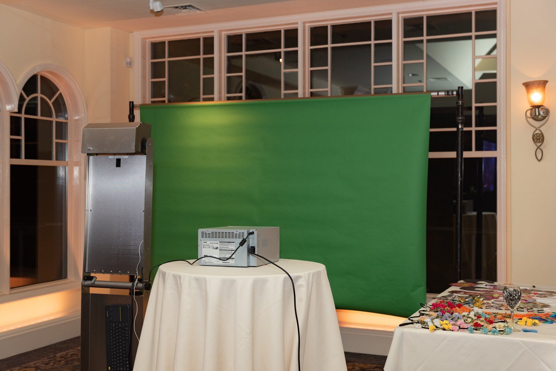 Event setup with green backdrop, podium, and tables in a lobby area
