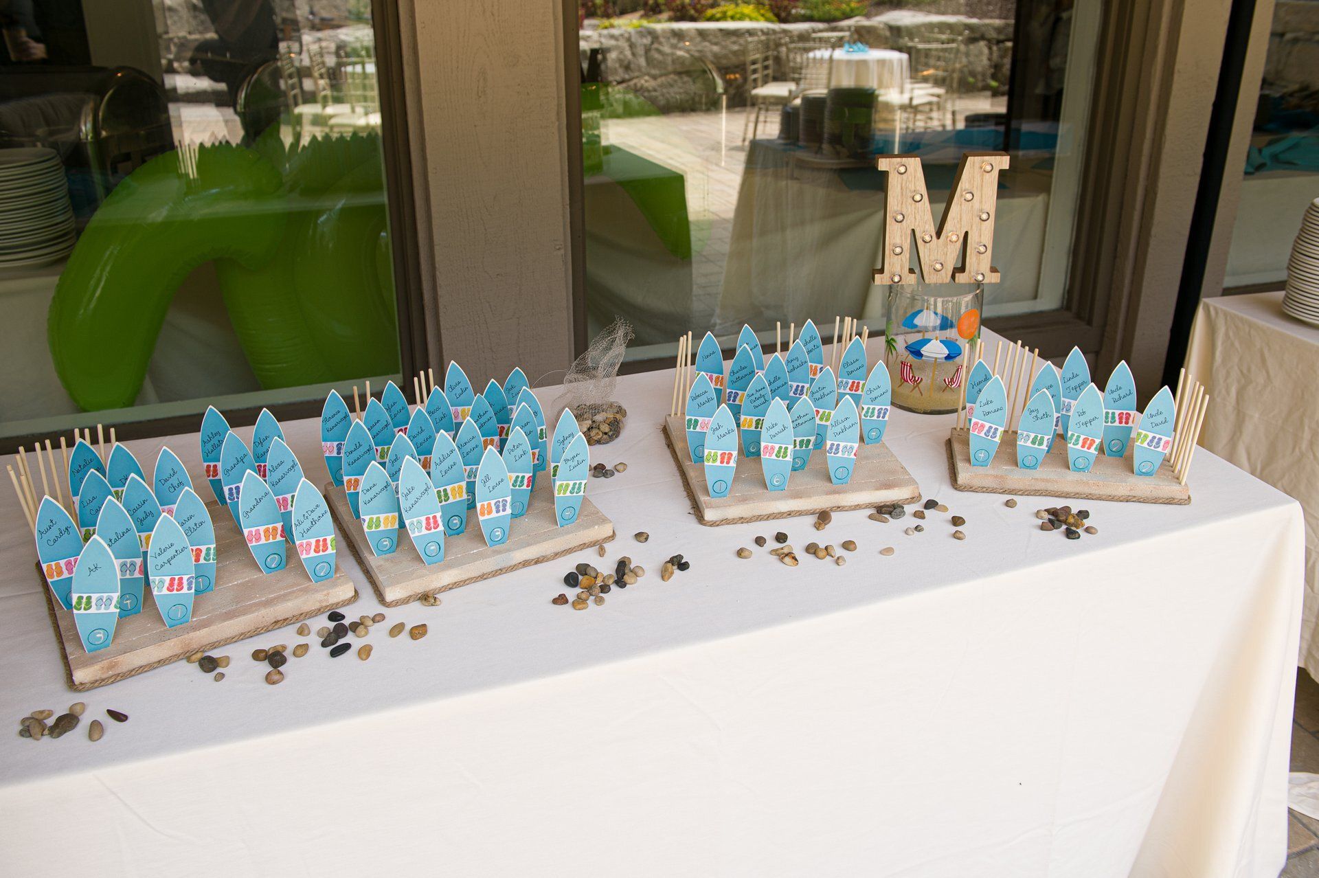 Table with blue-and-white party favor bags, scattered candies, and a decorative letter M