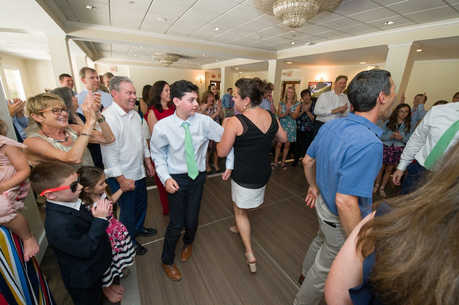 Guests dancing at a lively indoor party in a banquet hall