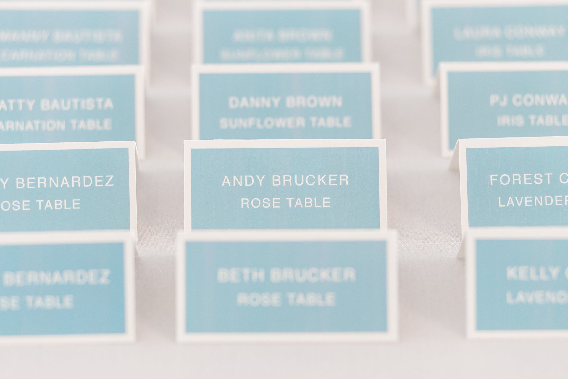 Blue and pink place cards arranged on a table at an event