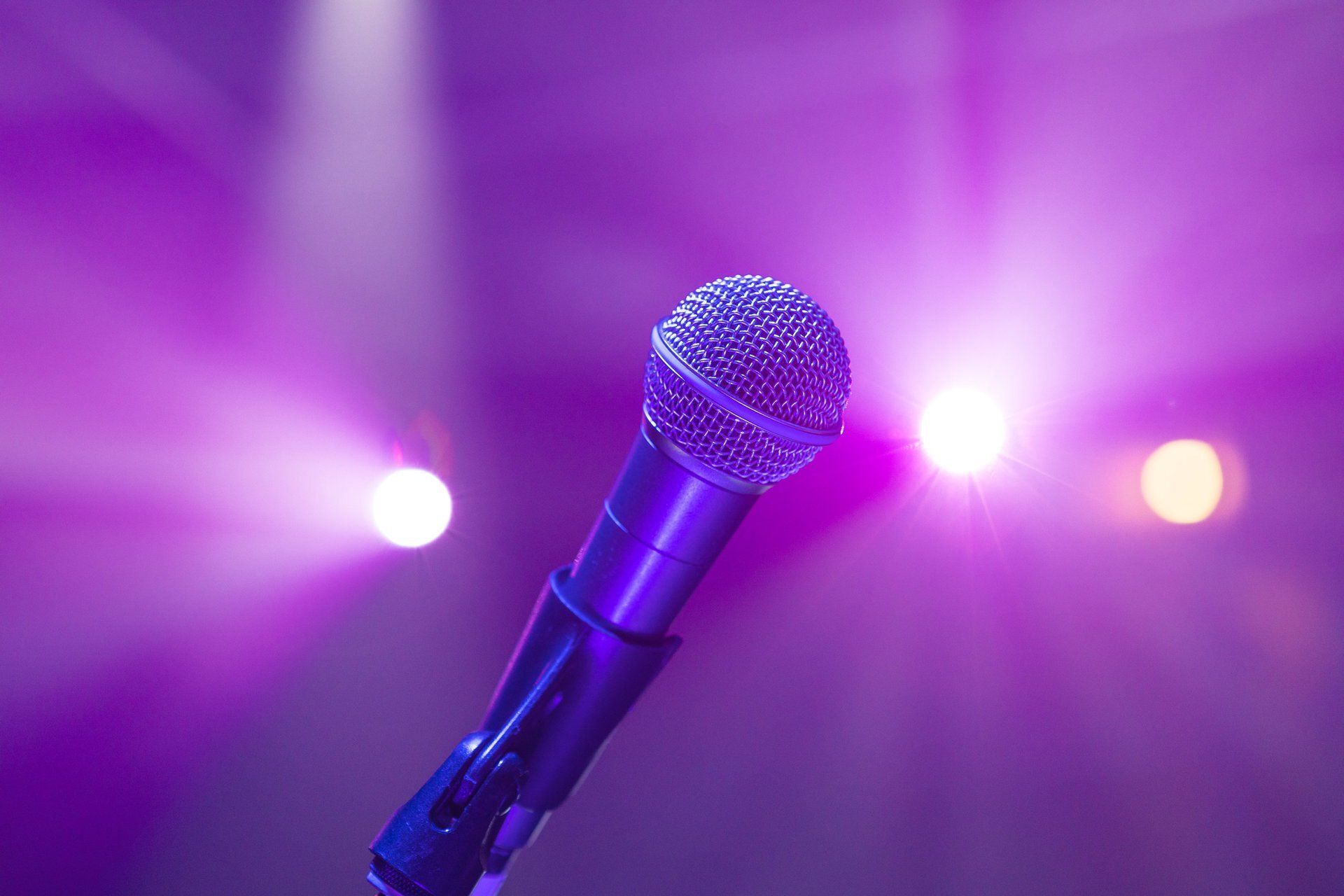 Microphone on stage with purple spotlights in the background