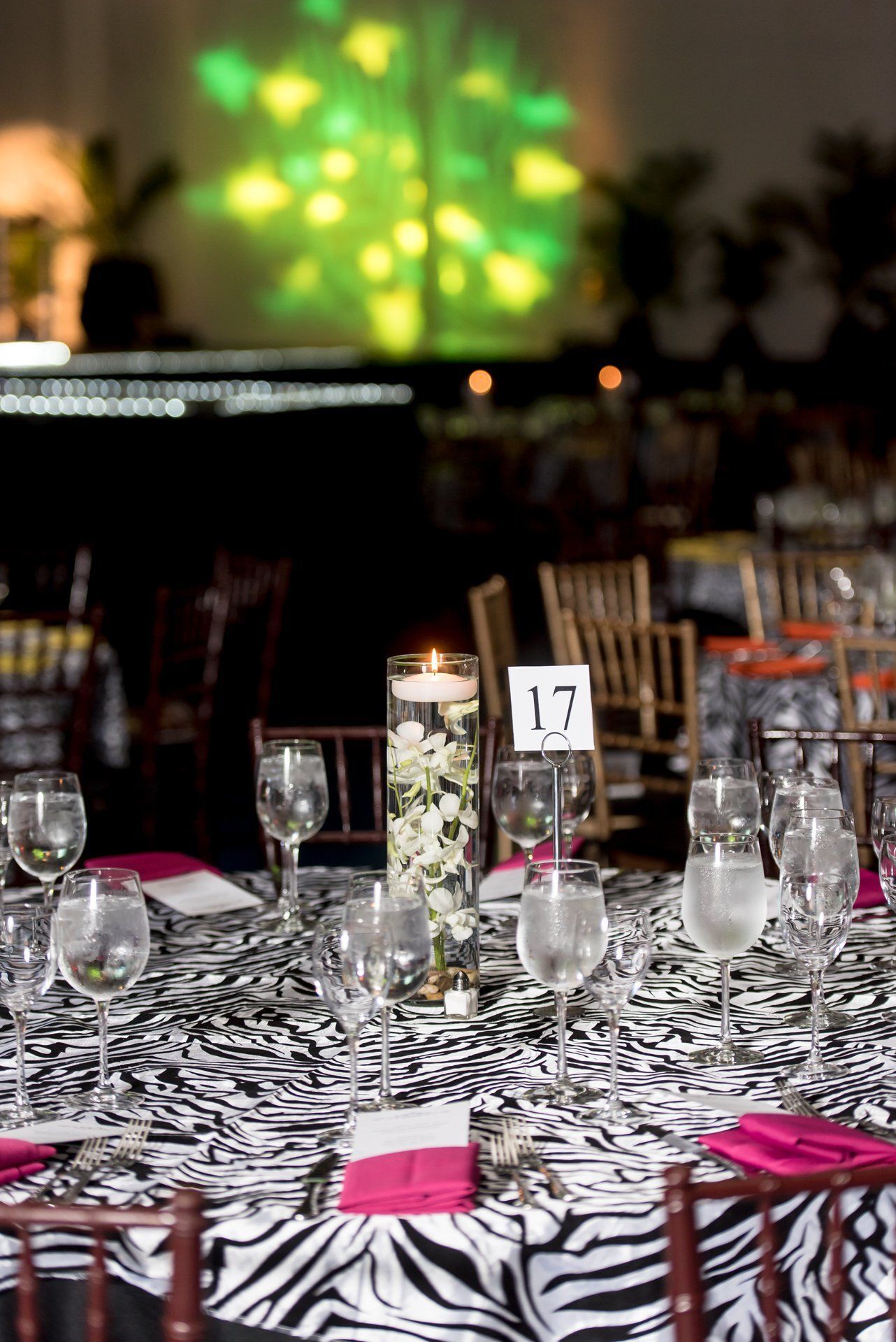 Set banquet table with wine glasses, candles, and pink napkins at an elegant event