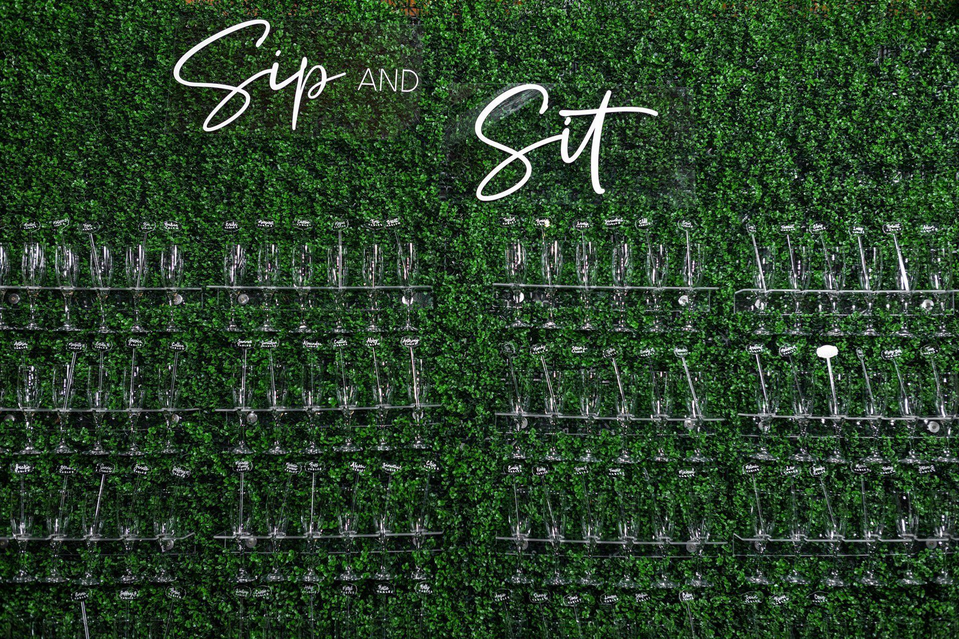 Sip and Sit sign above rows of seating on a green wall backdrop.