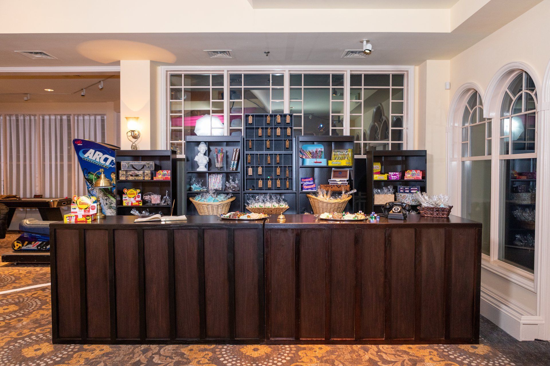 Hotel snack bar with chips, candy, and drinks on a long dark counter in a lobby.