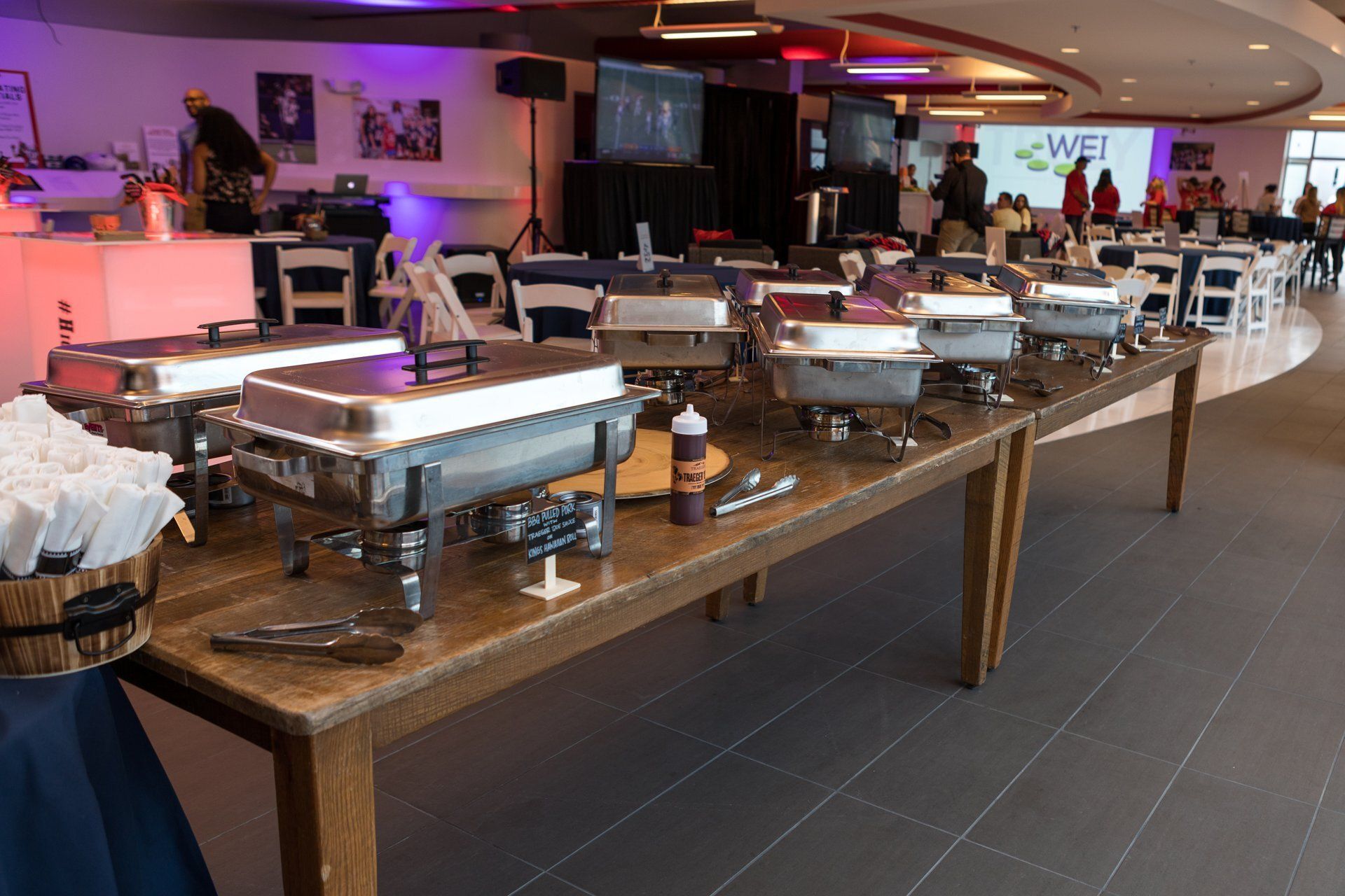 Buffet table with chafing dishes and serving utensils in a modern dining room