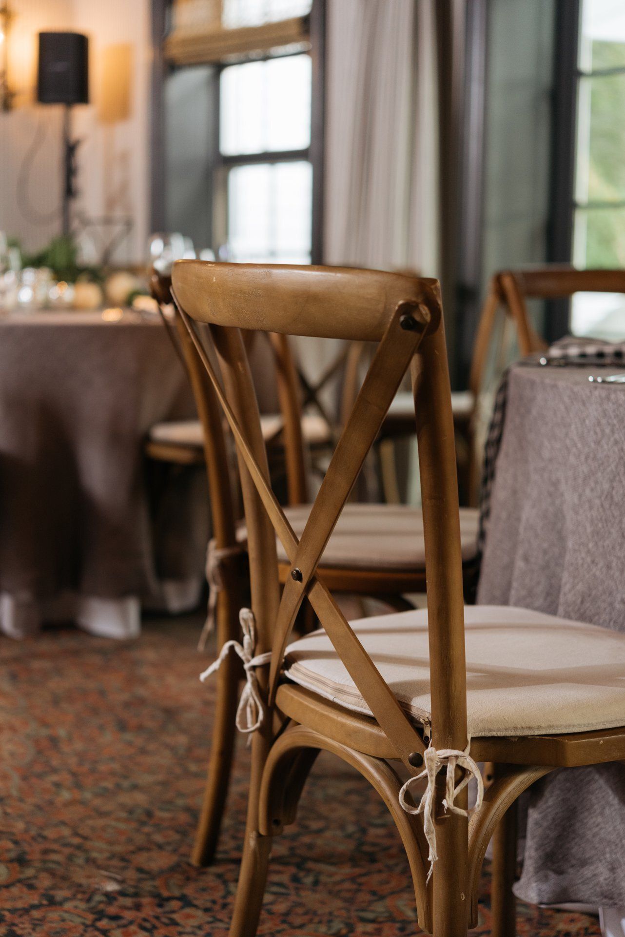 Wooden dining chair beside a table in a softly lit restaurant interior